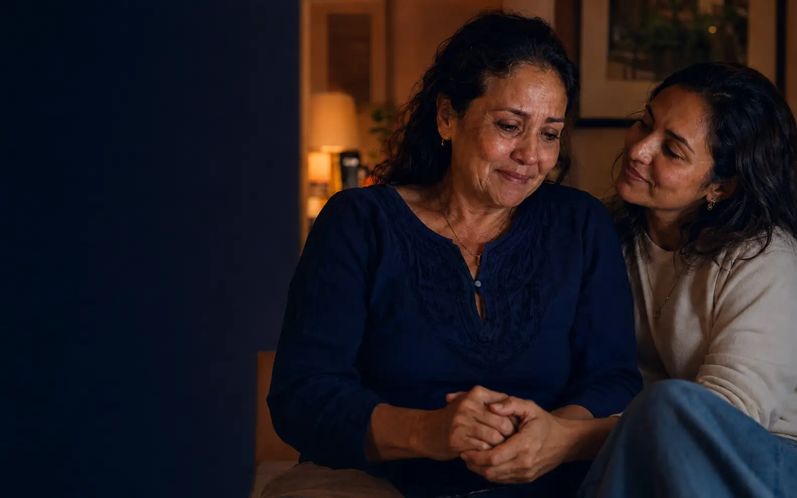 Mãe emocionada ao lado da filha em um momento de carinho